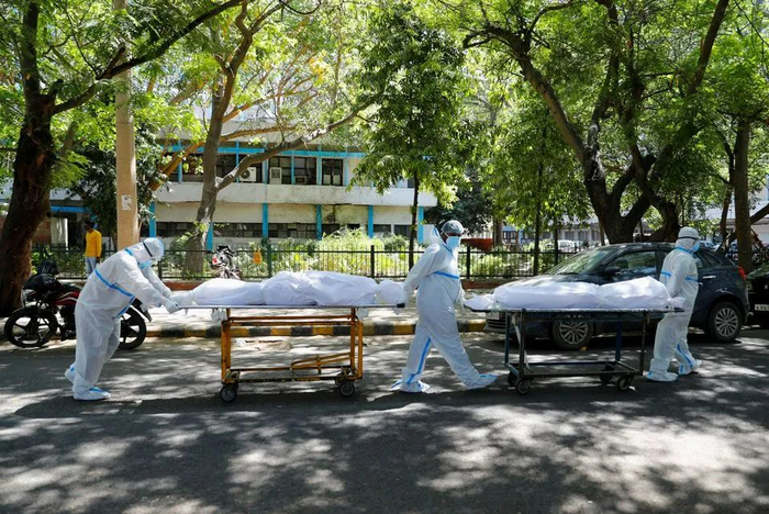 ▲资料图片：新德里一家医院外，几名医务工作者运送死于新冠肺炎的病人尸体。（路透社）