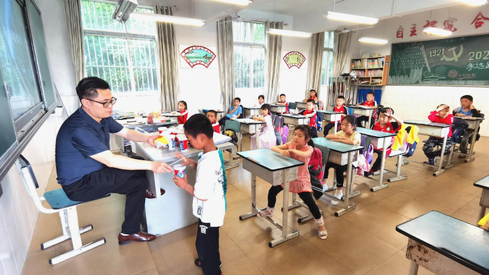 邓林老师给孩子们分发汉堡和可乐（央广网发 陈靖摄）