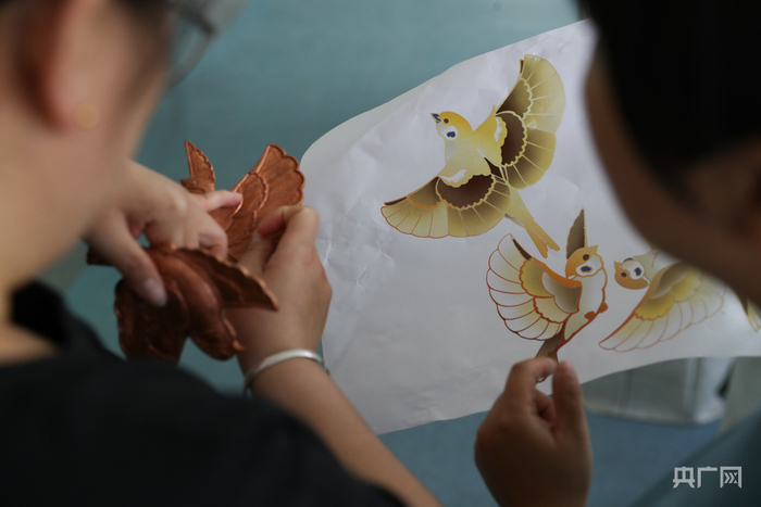 工作人员对照图纸讨论工作细节（央广网记者 韩靖 摄）