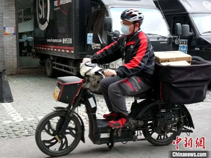 顺丰快递员正在忙碌着送件。叶秋云 摄