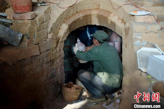 图为工作人员将坭兴陶放入古龙窑。　翟李强 摄