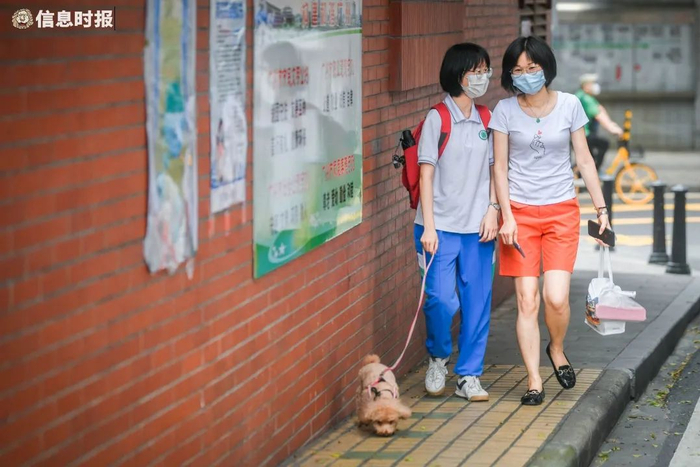 语文考试结束后，考生牵着狗狗与家长一起走。信息时报记者 胡瀛斌 摄