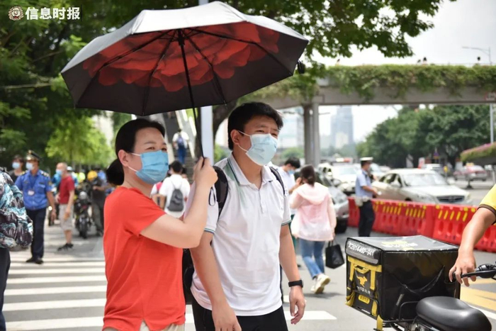 华附考场，语文考试结束后家长撑伞接走考生。信息时报记者 徐敏 摄