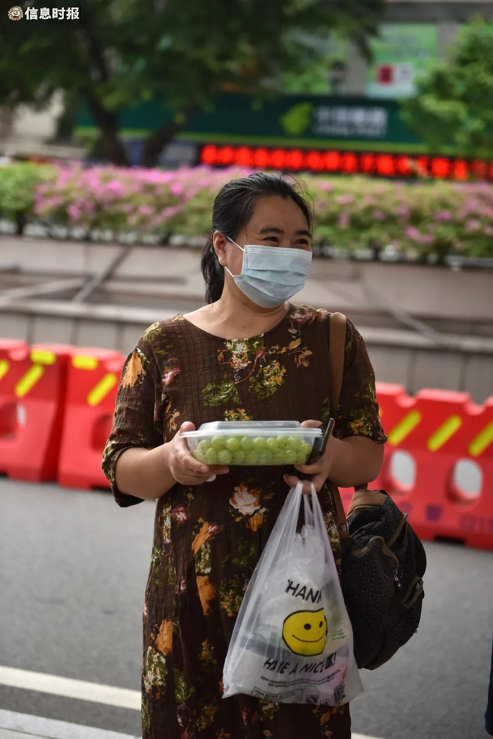 华附考场，涂女士带来水果和汤水等孩子出考场。信息时报记者 徐敏 摄
