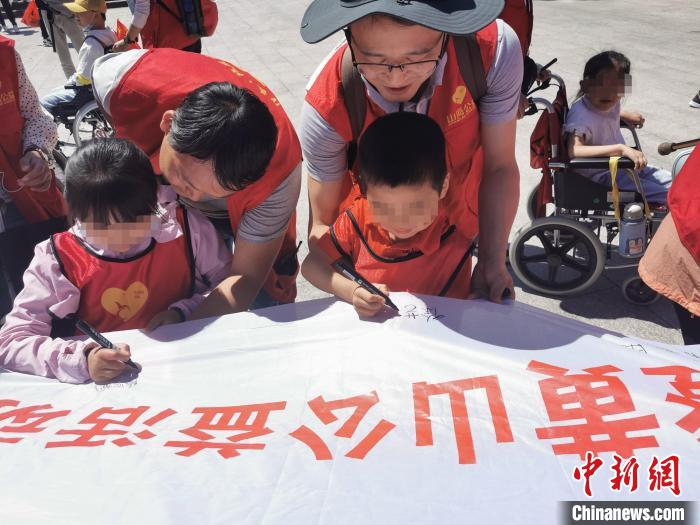 孩子们在横幅上签名留念。