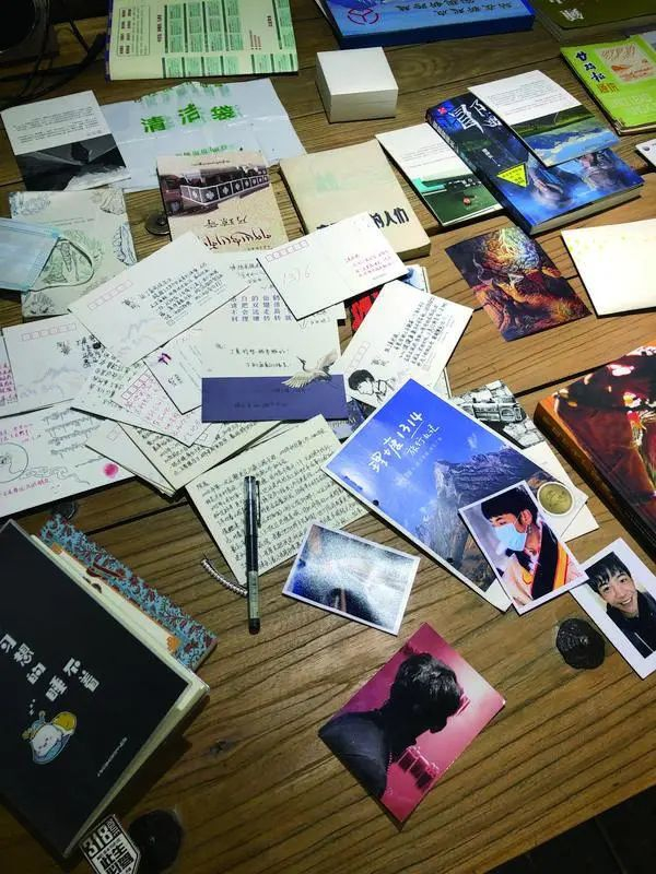 ▲5月24日，318旅行记忆博物馆三楼的长桌上，游客们留下的关于理塘的纪念品。新京报记者 韩沁珂&nbsp;摄