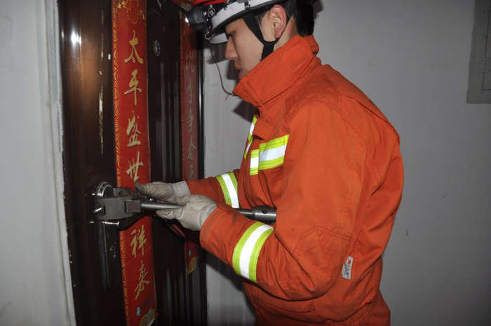 身穿消防服的黄禄通在救援中利用一技之长开锁