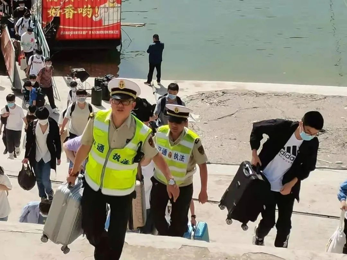 ▲6月5日，大昌中学高考考生乘船赴考，交警帮忙提行李。来源：巫山发布