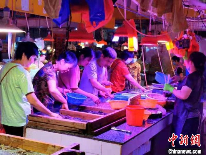 台城市民在早市选购“鳁鱼”。 李晓春 摄