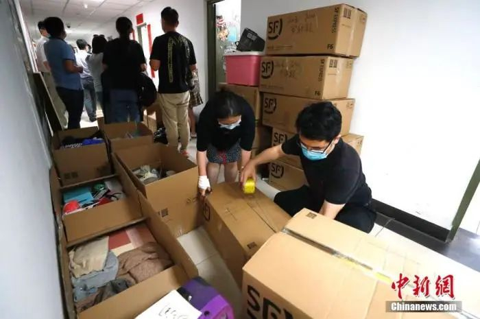 资料图：2020年，中国人民大学的教职工为不能返校的毕业生打包行李。中新社记者 富田 摄