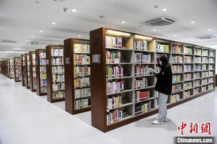 资料图：读者在书架前翻阅图书。　武俊杰 摄