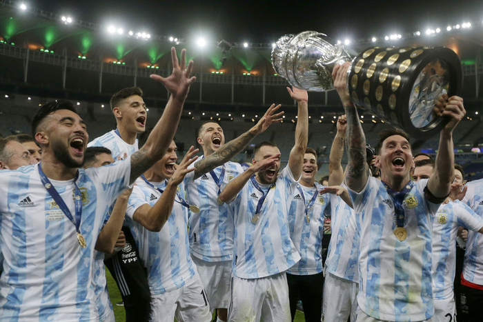 梅西高举奖杯与队友一起庆祝。阿根廷人终结28年大赛冠军荒。图/新华社