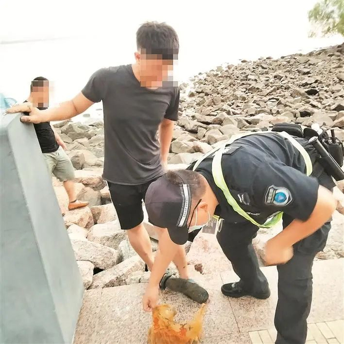 ▲深圳市海洋综合执法支队工作人员在深圳湾公园劝阻市民擅自下海捕捞。受访单位供图