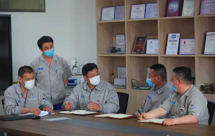 鹿新弟（中）在工作室内与同事们交流。新华社记者龙雷摄