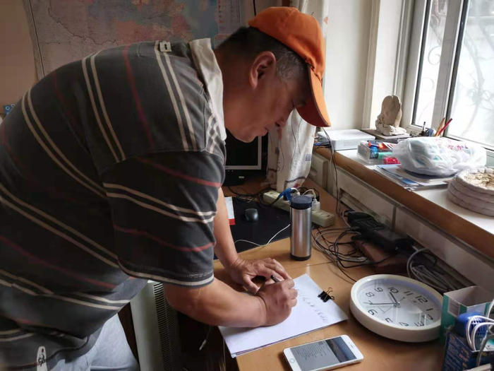 李凡在手机屏幕前等待和平鸽放飞。实习生 许琳迪 摄