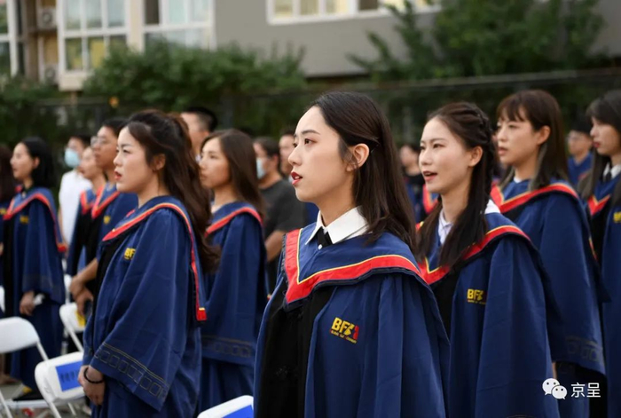 毕业生面向国旗唱国歌