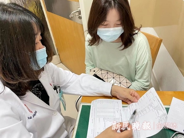 图说：骆肖群正在给患者解答检测报告  左妍 摄（下同）