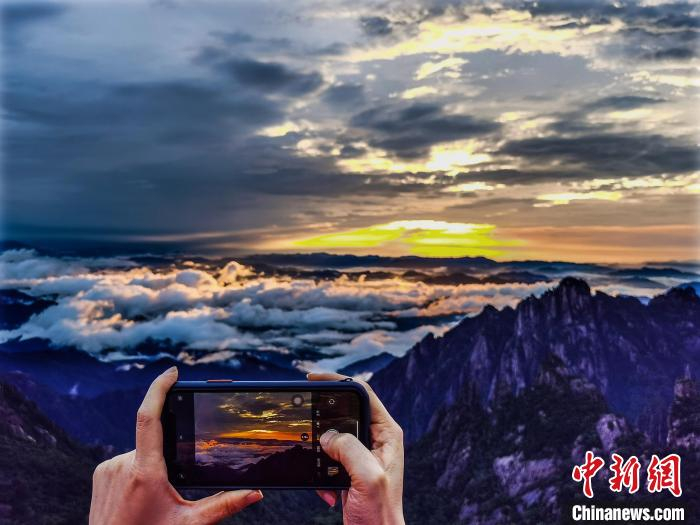 云海翻涌，游客手机拍照留念 李金刚 摄