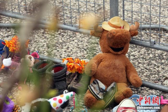 当地时间6月2日，在位于多伦多的加拿大安大略省省议会大楼门前，人们摆放了各式玩偶、 上百双童鞋和鲜花、留言卡等，为日前该国卑诗省（又译不列颠哥伦比亚省）一处原住民寄宿学校旧址发现215具儿童遗骸之事志哀。 中新社记者 余瑞冬　摄