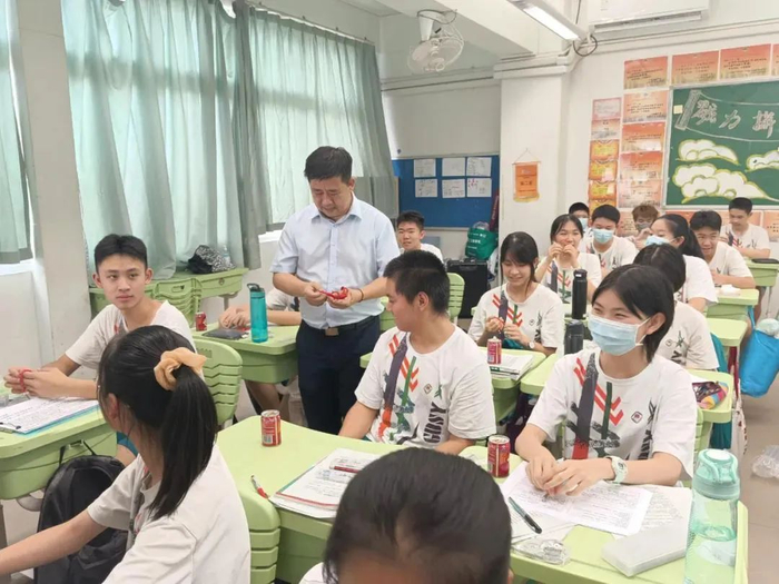 广东实验中学校长全汉炎给学生送祝福红绳。学校供图