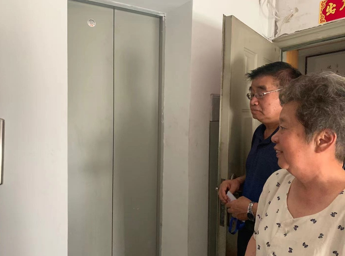 住在6层的老人高兴地等待乘坐电梯下楼。