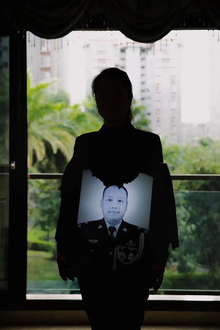 2021年12月24日，云南西双版纳，家人怀抱着缉毒警察蔡晓东同志的遗照。新京报记者 郑新洽 摄