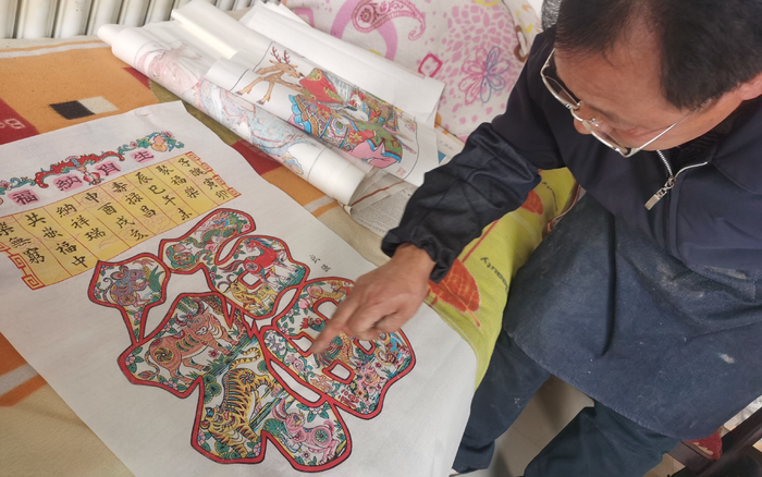 韩金刚向记者讲述武强年画。新京报记者 王颖 摄