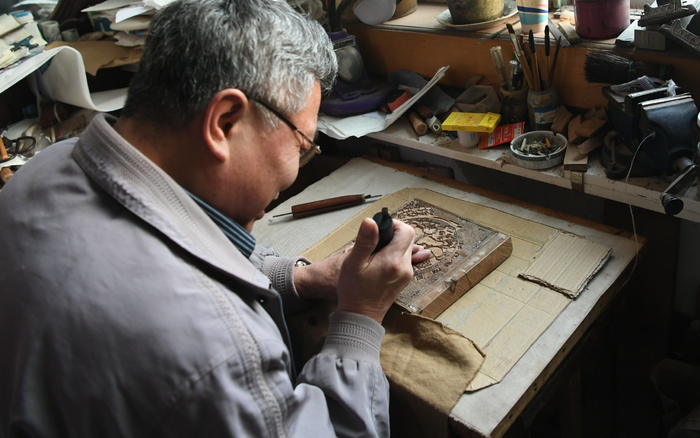 马习钦正在制作木版，他16岁就入行了。新京报记者 王颖 摄