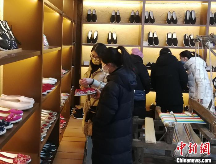 游客在“团结北庄”手工坊里购物。　俱凝搏 摄