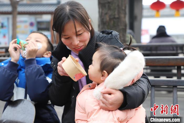 孩童品尝刚刚熬制出锅的腊八粥。　刘鸿儒 摄