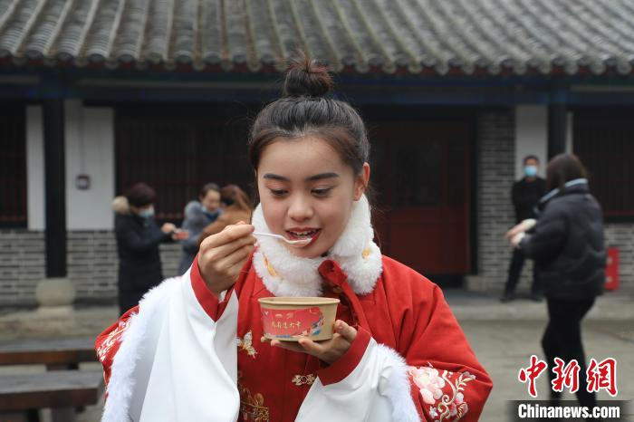 游客品尝热气腾腾的腊八粥。　刘鸿儒 摄