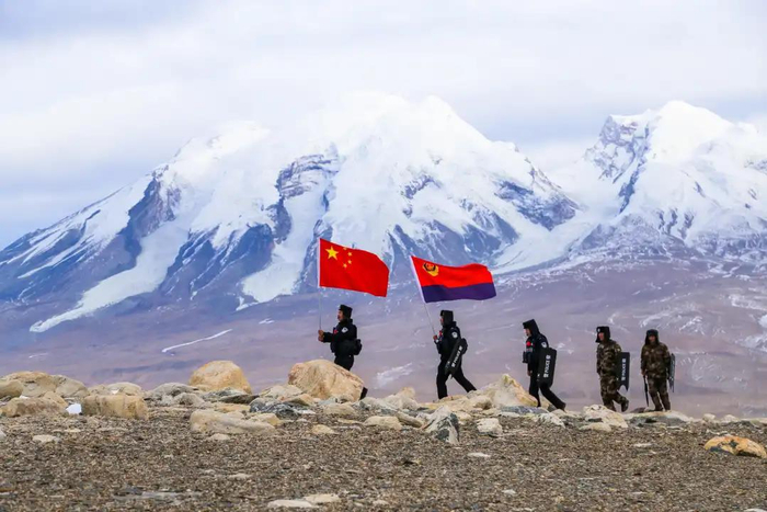图为民警登顶边境前沿黑石滩山后进行巡查