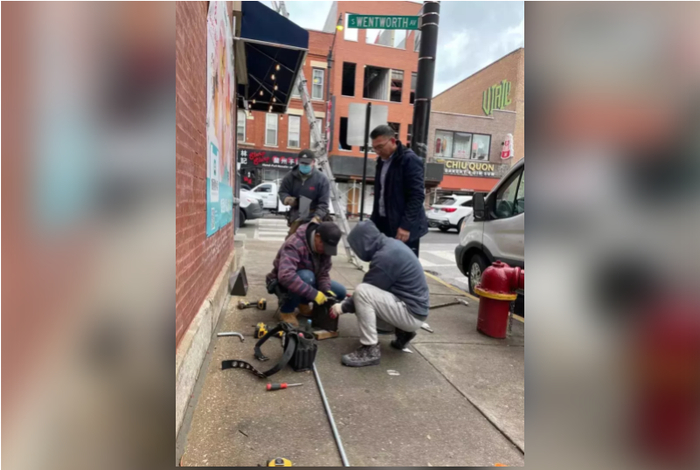 图为华埠治安基金会正在亚历山大街附近安装节能灯。华埠治安基金会供图 来源：美国世界日报