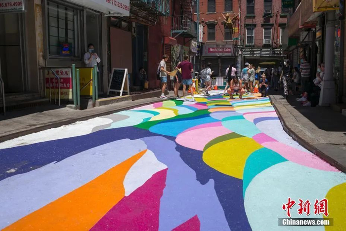 图为美国纽约曼哈顿中国城宰也街的彩绘路面吸引众多游客驻足。中新社记者 廖攀 摄 