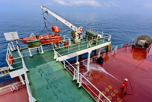 山东海运“山东人和”号货轮海员们在冲洗甲板。摄影/章轲