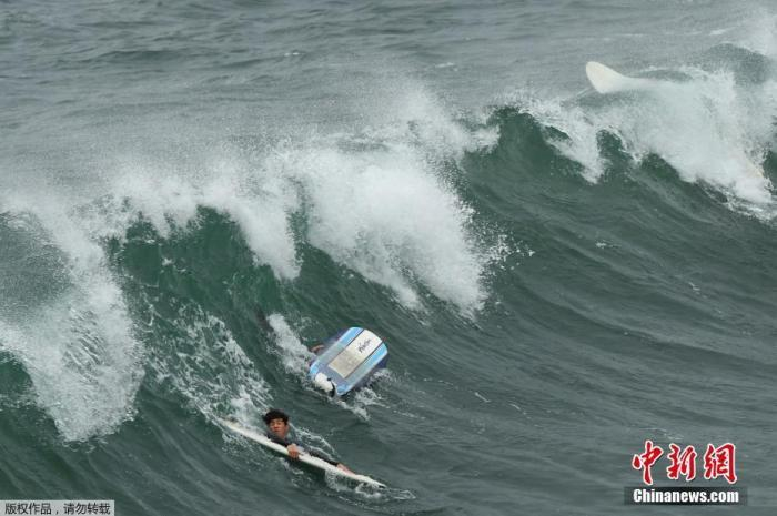 当地时间1月15日，在汤加发生海底火山喷发后，美国国家气象局发布了针对美国整个西海岸的海啸警报。图为美国国家气象局发布海啸警报后，冲浪者在加州海边冲浪。