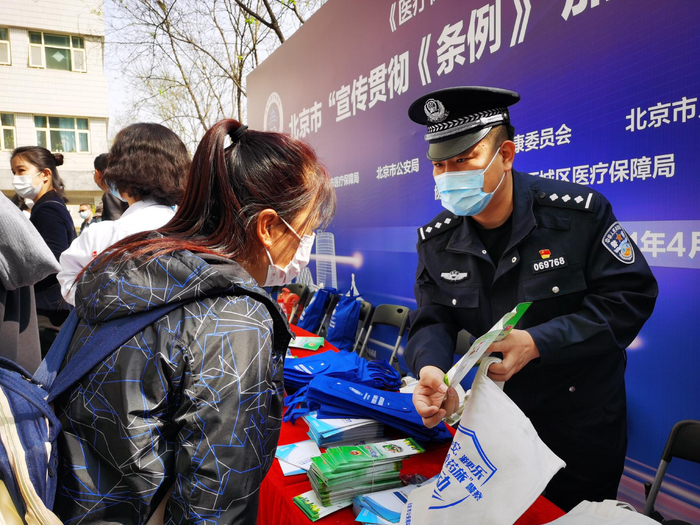北京打击欺诈骗取医保基金宣传月期间，环食药旅总队民警向群众普及法律知识。环食药旅总队供图