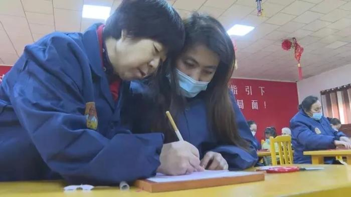 郝桂芬耐心指导学员学习剪纸。古丽阿亚提 摄