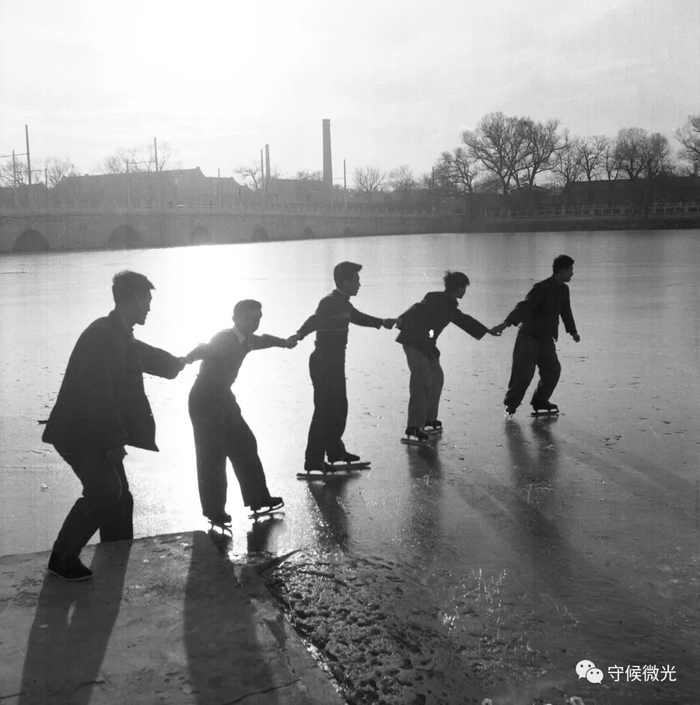 1957年12月，北京，几名年轻人手拉手走上冰场。贾化民/摄