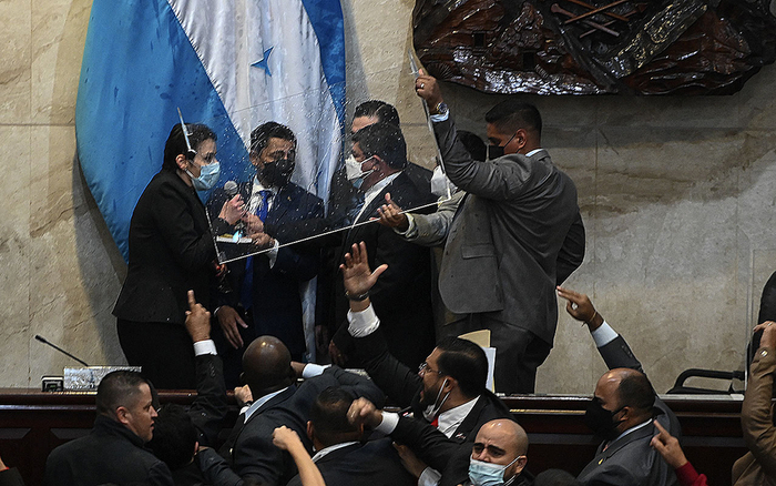 自由和重建党阵营的议员与萨尔瓦多党议员在卡利克斯（不在画面内）宣誓时抗议。