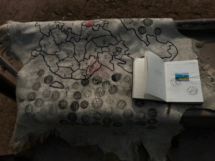 　　▲2022年1月1日，乐晓雲已经进入重庆境内，他的地图盖满了邮戳，小本上的人名也密密麻麻。新京报记者 杨雪 摄