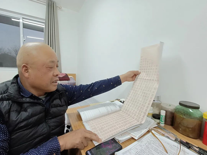 ▲探工汪照宏查看之前钻探记录的图纸。新京报记者 吴采倩 摄