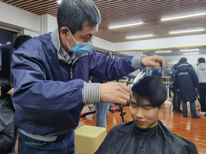 天津大学机械工程学院副院长曹树谦教授为学生剪发。天津大学供图