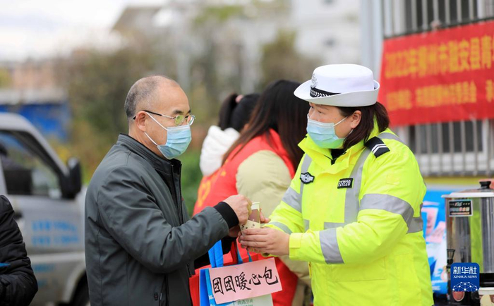 1月17日，在209国道广西柳州市融安县段“春运爱心驿站”，交通辅警为司乘人员送姜糖茶。新华社发（谭克兴摄）