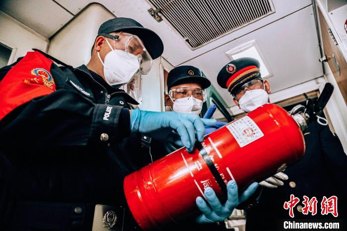 何凯明和列车工作人员一同检查车上消防设施 张磊 摄