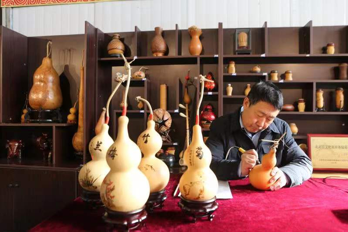 牛氏火绘葫芦第四代传承人牛成果在葫芦上绘图。李在滨 摄