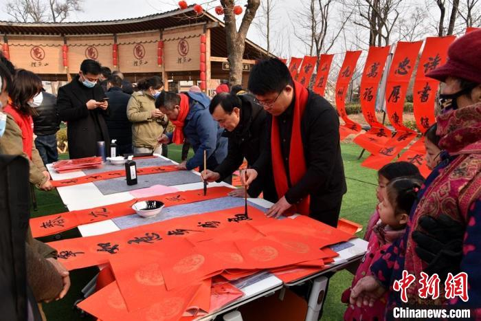 书法家们挥毫泼墨为当地村民书写春联送福字。　朱志庚 摄