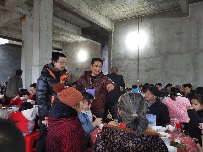 李树全带着儿子给乡亲们敬酒。