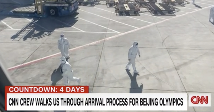 CNN记者拍摄的从飞机到酒店经历一系列防疫的经历，图为防疫人员在停车坪等待为来宾行李消毒（下同）