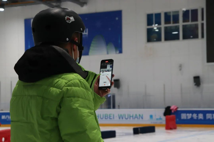 吴先生第一次带着孩子来冰场滑冰，他拿起手机为孩子记录下这新奇的体验。